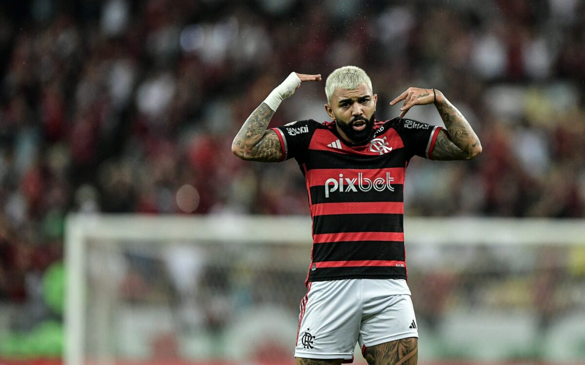 O jogador de futebol Gabigol é fotografando durante uma partida do Flamengo, seu clube. A foto mostra o jogador gesticulando os braços como se reclamasse de algo.
