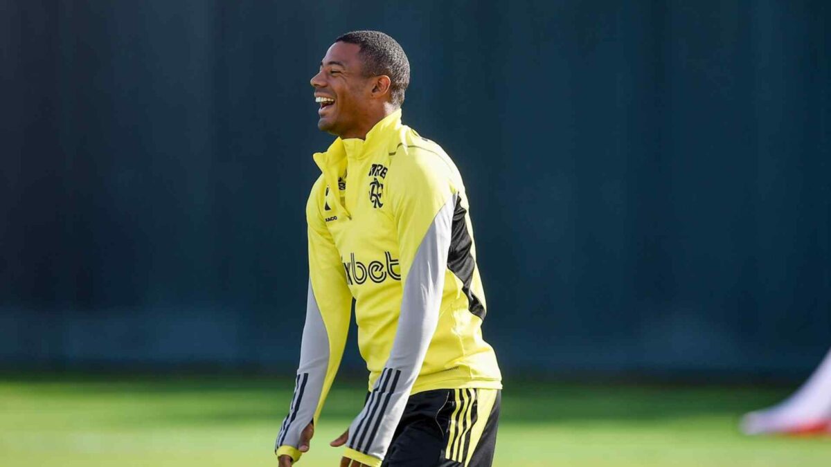 O jogador uruguaio Nico de la Cruz está perfilado e rindo. Nico está vestindo trajes de treino do Flamengo.