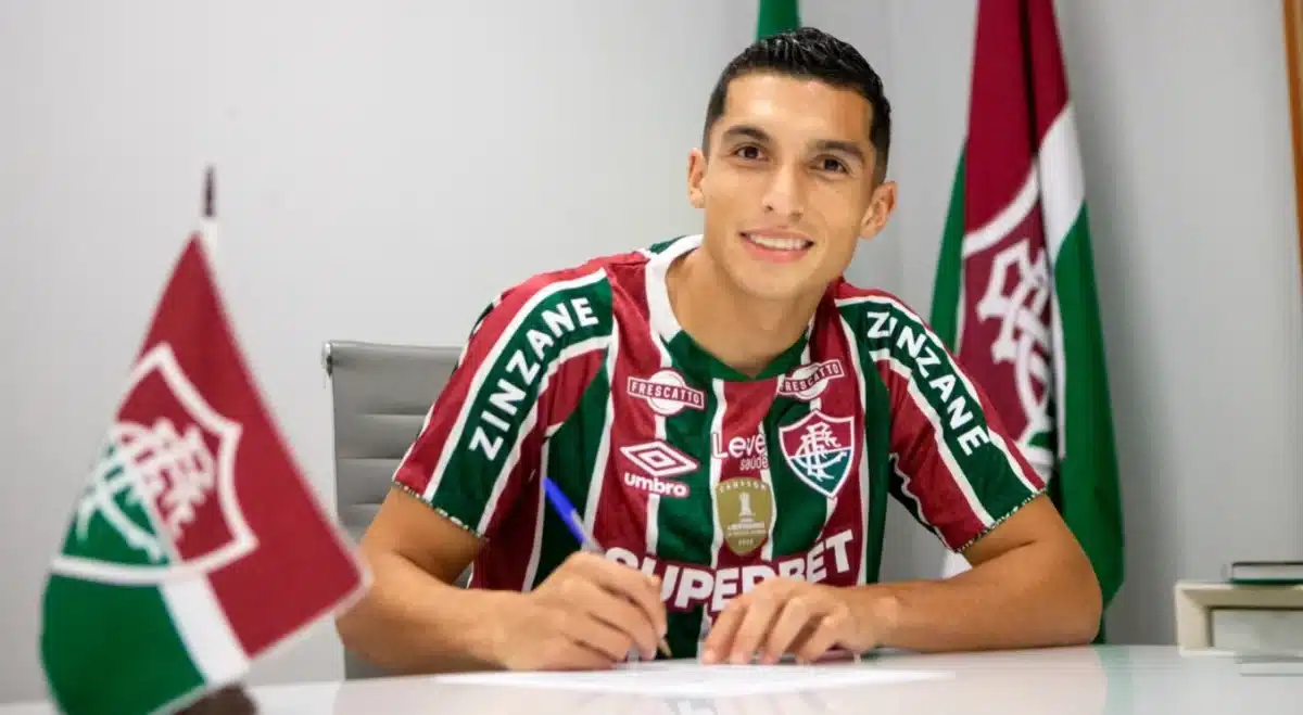 Kevin posa para foto com a camisa do Fluminense ao assinar contrato com o clube carioca.
