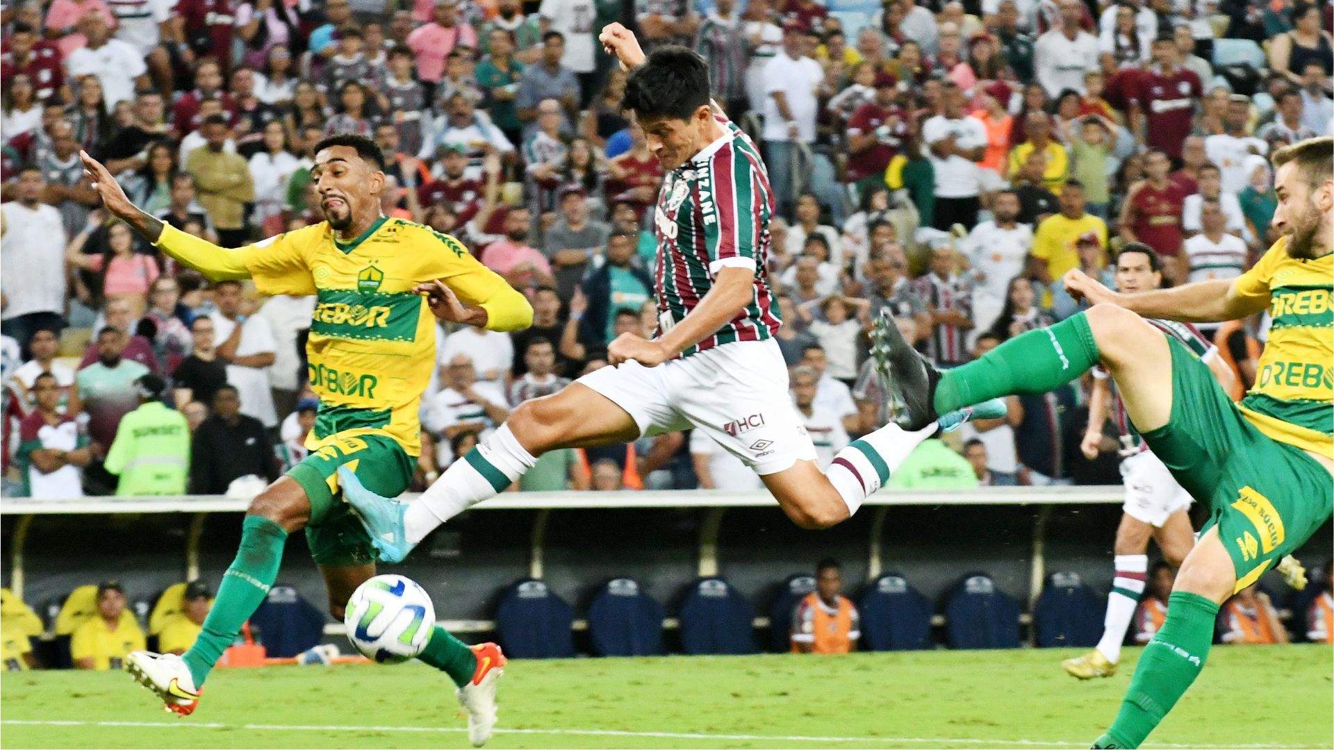 Jogador do Fluminense German Cano tenta chutar a bola em disputa com jogadores do Cuiabá.