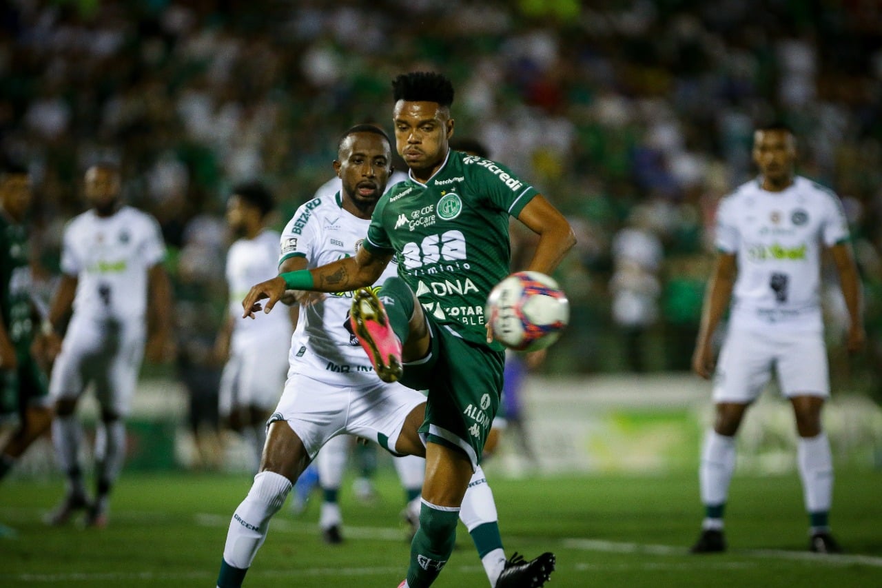 Jogador do Guarani tenta dominar a bola enquanto recebe marcação forte do jogador do Goiás.