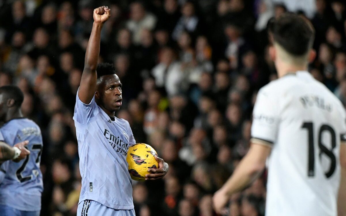 Vini Jr, durante jogo do Real Madrid, ergue o punho esquerdo cerrado pro alto ao comemorar um gol contra o Valencia.