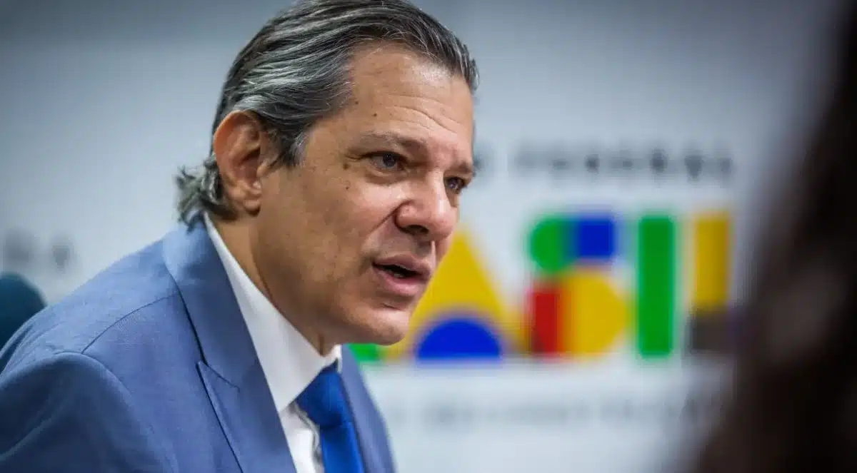 Imagem coloca o ministro da Fazenda Fernando Haddad em destaque. Ao fundo, parte da logomarca do Governo Federal.