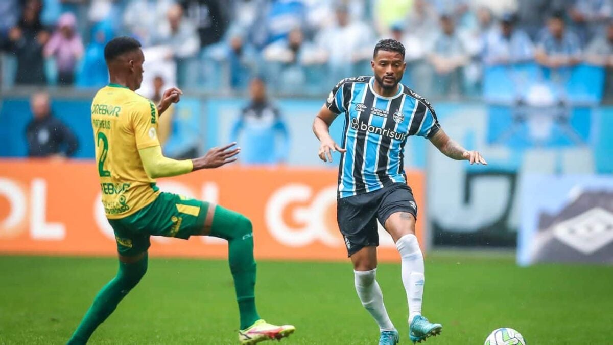 Jogador do Grêmio corre com bola dominada e marcação do jogador d Cuiabá.