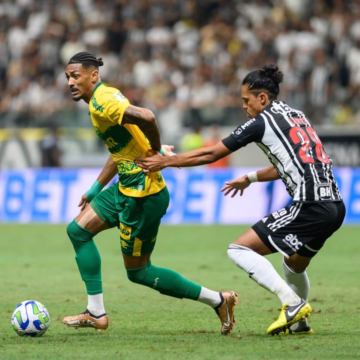 Jogadores do Cuiabá e do Atlético-MG em disputa pela bola no meio de campo.